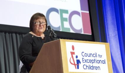 Jolly Piersall, CEC 2020 Convention Program Co-Chair, speaking on stage at the convention in front of a podium with CEC's logo on it