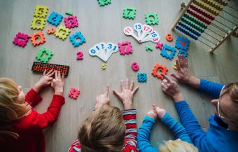 young children and teacher using visuals and fingers to count during math lesson