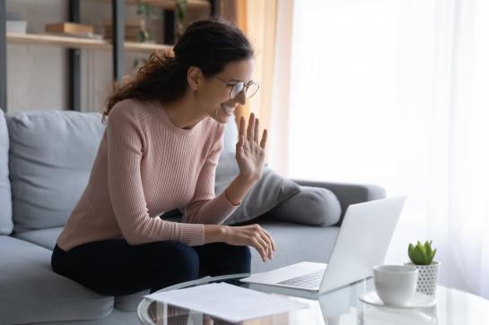 Woman smiling waving at computer